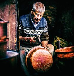 Man working on utensil in workshop