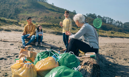 Group of volunteers resting and eating after cleaning the beach