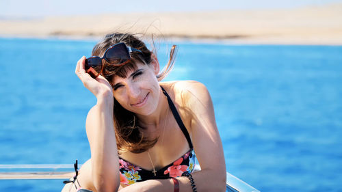 Summer, sea, portrait, beautiful young brunette woman wearing a bathing suit and sunglasses
