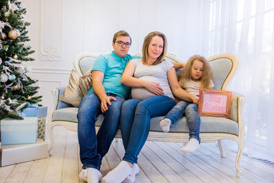 Young woman using laptop while sitting on sofa at home