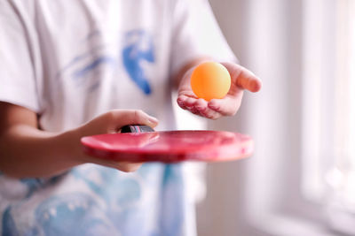 Close up of boy playing ping pong ball at home during covid-19 pandemic. child active activities.