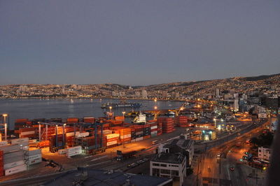 High angle view of illuminated city by buildings against sky
