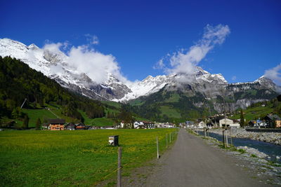 Panoramic shot of field and houses against sky