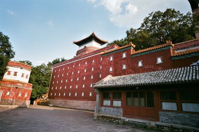 Exterior of house by building against sky