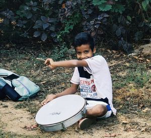 Portrait of boy sitting on land