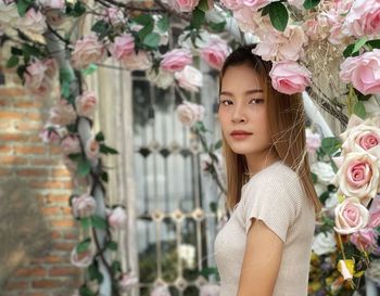 Portrait of beautiful woman ,asian girl,standing by pink flowering bouquet  of pink roses