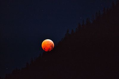 Low angle view of orange moon in sky