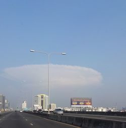 Street by road against sky in city