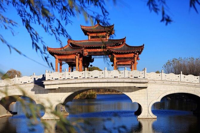 architecture, built structure, building exterior, water, blue, tree, arch, reflection, clear sky, place of worship, sky, incidental people, travel destinations, religion, waterfront, outdoors, famous place, low angle view, travel, day
