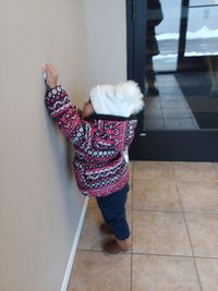 Rear view of woman walking on floor at home