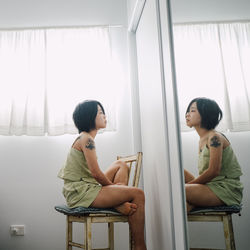 Young woman sitting on sofa at home