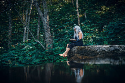 Low angle view of woman sitting in lake