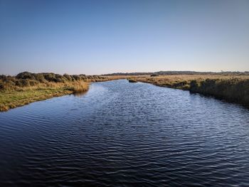 Scenic view of lake against clear blue sky