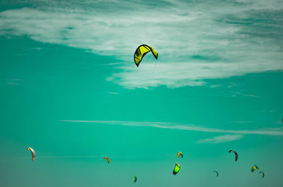 People paragliding over sea against sky