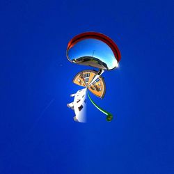 Low angle view of ferris wheel against blue sky