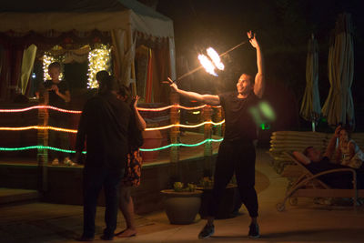 Rear view of people dancing at night