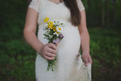 Midsection of woman holding flowering plant