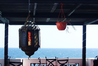 Close-up of lantern hanging by sea
