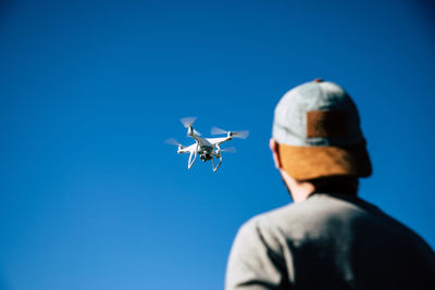 Low angle view of airplane flying against clear blue sky