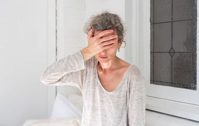 Stressed mature woman sitting at home