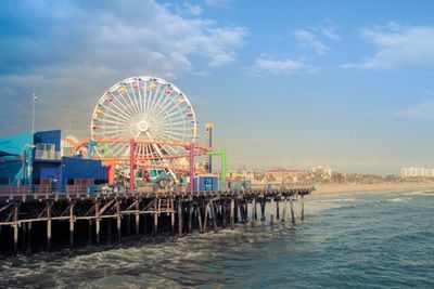 Ferris wheel at beach against sky