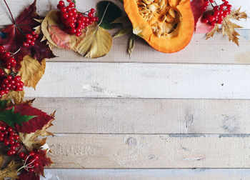 Directly above shot of red currants and pumpkin on table