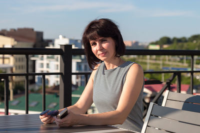 Young woman looking away while sitting on bench