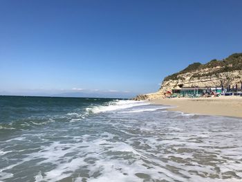 Scenic view of beach against clear blue sky