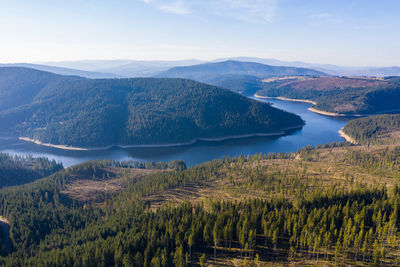 Aerial drone shot of a lake and green forest in belis, transylvania, romania