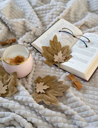 Christmas decorations with lights, hot drink, fruits and a good book