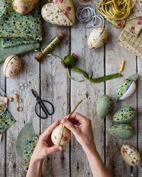 Top view of hands holding nest with easter eggs in kimekomi ornaments style. handmade easter decor 