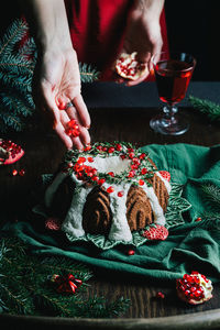 Gingerbread bundt cake for christmas with pomegranate and christmas decorations over dark background