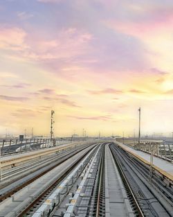 Railroad tracks against sky during sunset