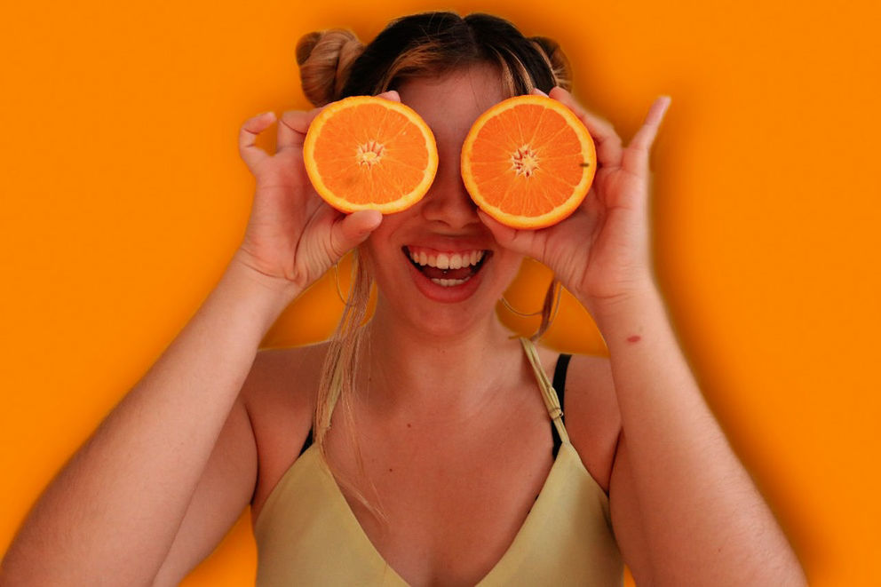 PORTRAIT OF WOMAN HOLDING ORANGE