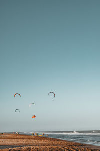 Scenic view of sea against clear sky with kitesurfing 