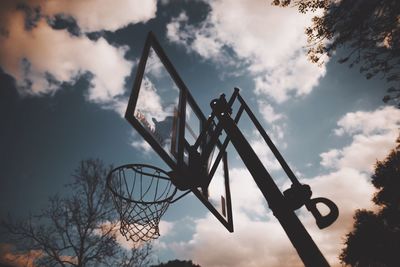 Low angle view of basketball hoop against cloudy sky