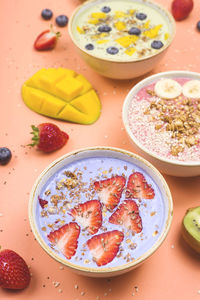 Colored smoothies breakfast with fruits served on bright table