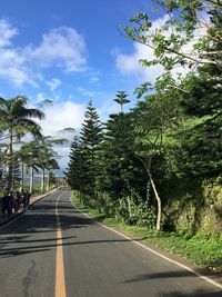 Road amidst trees against sky