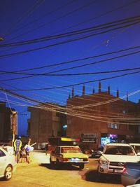 Cars on road in city against clear blue sky