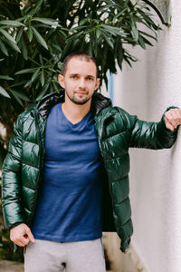 Portrait of handsome man standing by wall