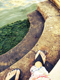 Low section of woman standing by water