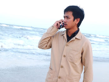 Mid adult man standing on beach