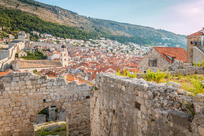 Old town by mountain against sky