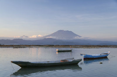 Boats moored in lake against sky