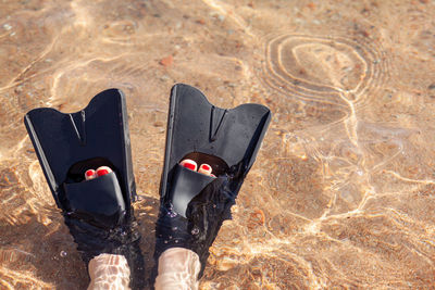 Low section of person standing on sand