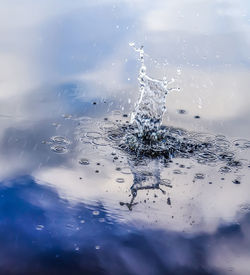 Close-up of water splashing in sea against sky