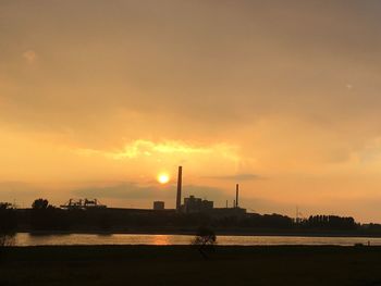 Silhouette of factory at sunset