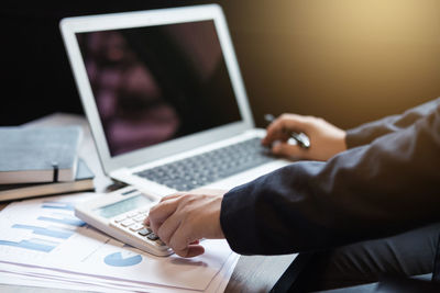 Midsection of businessman working over graph on table at office