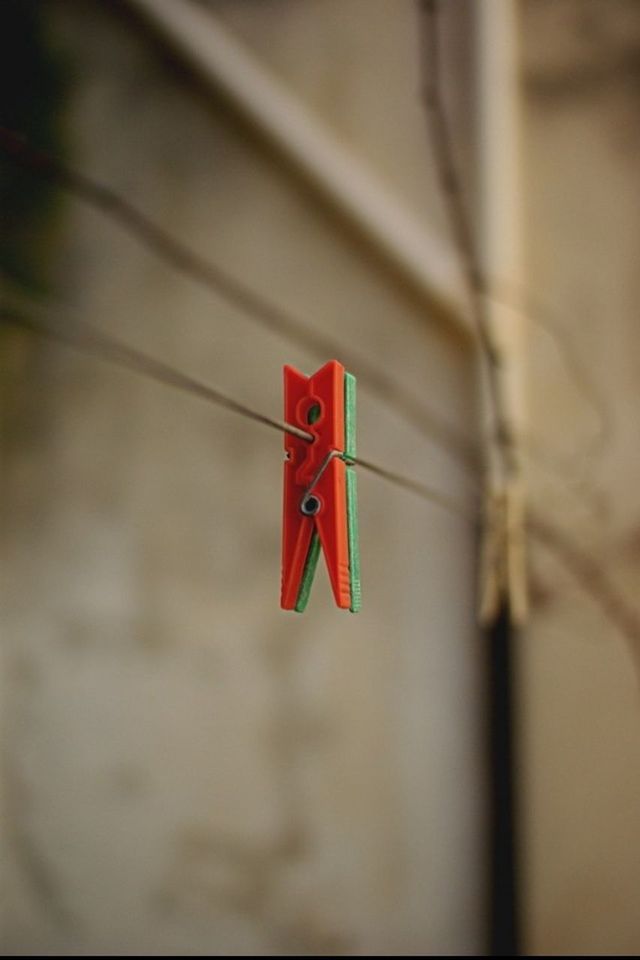 red, focus on foreground, close-up, hanging, selective focus, no people, text, heart shape, day, wall - building feature, outdoors, love, low angle view, pole, communication, western script, decoration, white color, flag