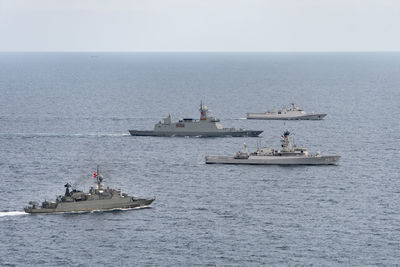 Boats sailing in sea against sky